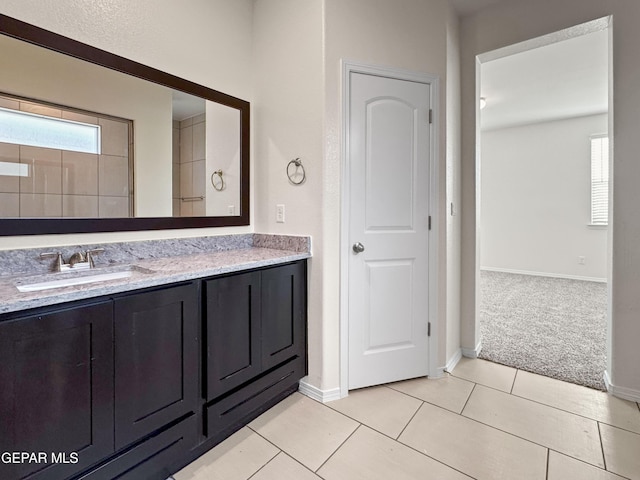 bathroom featuring tile patterned flooring, plenty of natural light, vanity, and baseboards