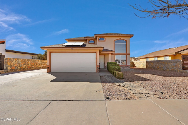 view of front facade featuring a garage, driveway, fence, and stucco siding