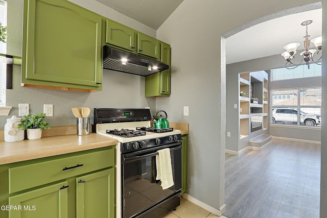 kitchen with green cabinetry, light countertops, under cabinet range hood, a notable chandelier, and gas stove