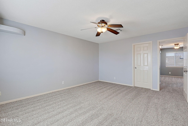 unfurnished room featuring a textured ceiling, ceiling fan, light carpet, and baseboards