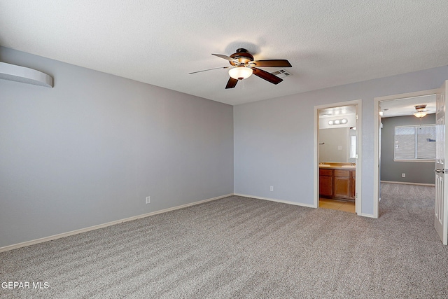 unfurnished bedroom featuring light carpet, baseboards, visible vents, and a textured ceiling