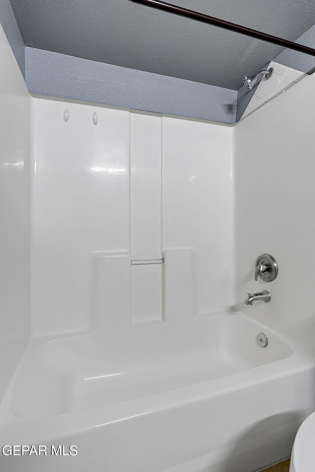 full bathroom with shower / tub combination and a textured ceiling