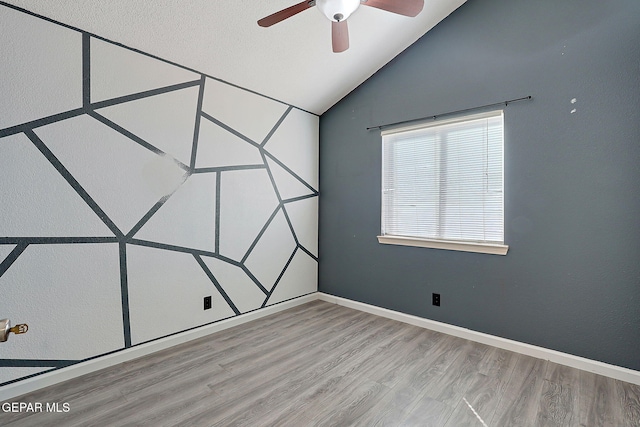 unfurnished room with light wood-style floors, lofted ceiling, baseboards, and a ceiling fan