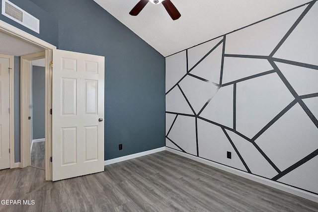 unfurnished bedroom with lofted ceiling, wood finished floors, visible vents, and baseboards