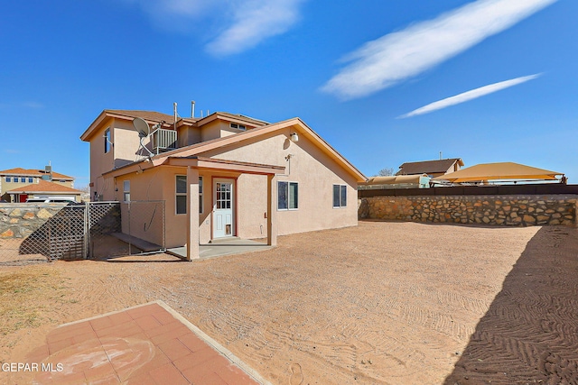 back of house with a patio area, fence, and stucco siding