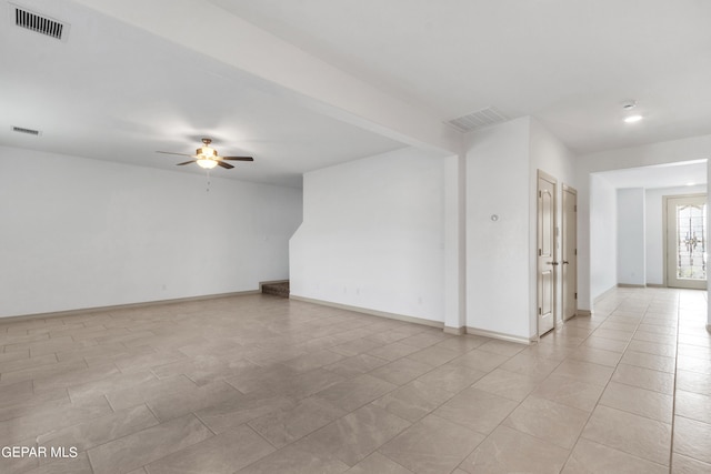 tiled spare room featuring ceiling fan