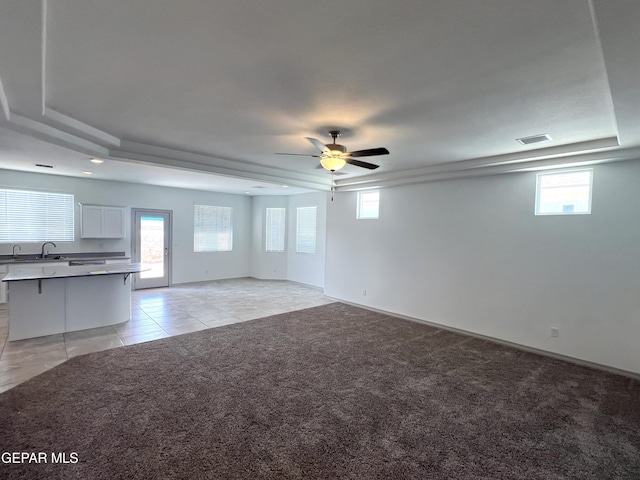14916 Concept Ct, El Paso, TX 79938 - unfurnished living room with a tray ceiling, ceiling fan, and plenty of natural light