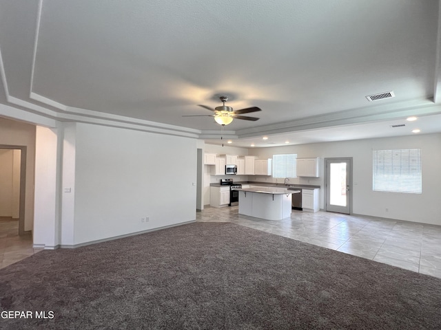 14916 Concept Ct, El Paso, TX 79938 - unfurnished living room with ceiling fan, a raised ceiling, light tile patterned floors, baseboards, and light carpet