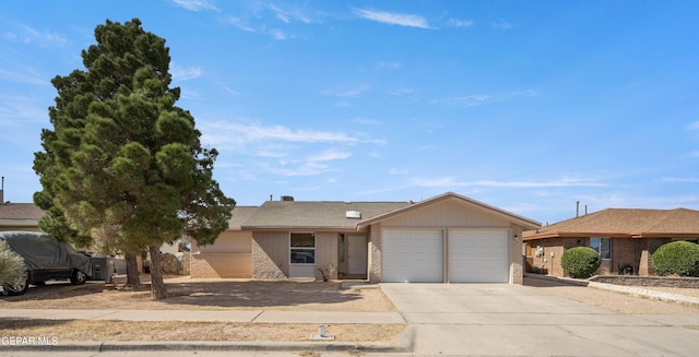 ranch-style house featuring a garage, concrete driveway, and brick siding