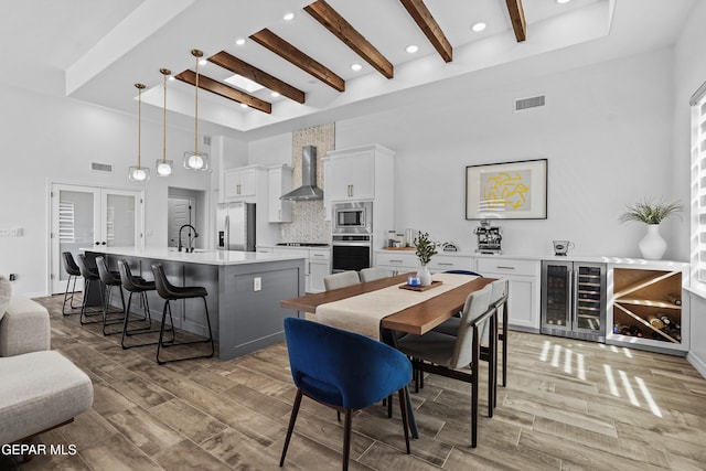 dining space with wine cooler, wood finish floors, and visible vents