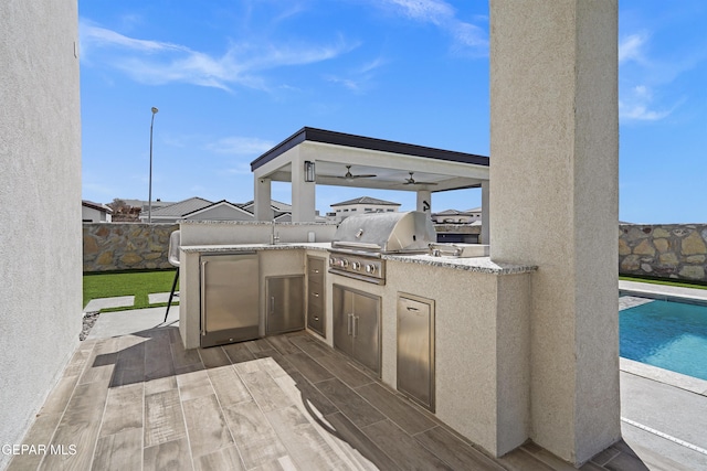 view of patio / terrace featuring a fenced in pool, a fenced backyard, a sink, and area for grilling