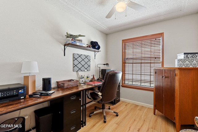 office area with light wood-style floors, ceiling fan, a textured ceiling, and baseboards