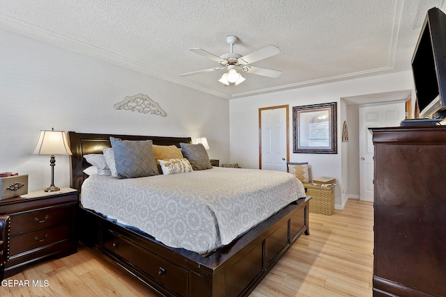 bedroom featuring light wood-type flooring, ceiling fan, a closet, and a textured ceiling