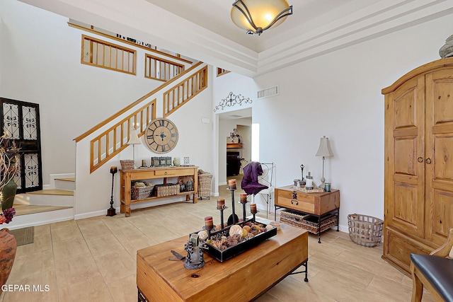 living room with stairway, baseboards, a fireplace, and visible vents