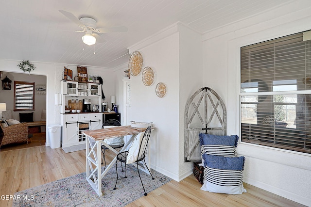 dining space featuring light wood-style flooring, baseboards, and a ceiling fan