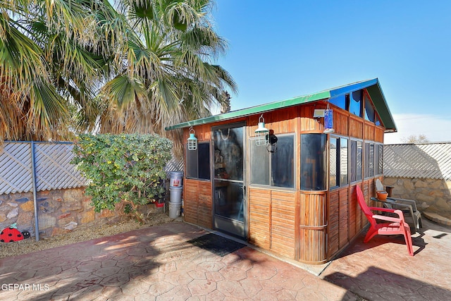 view of outdoor structure featuring an outbuilding and fence