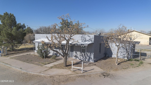 view of front of property with metal roof, fence, and stucco siding