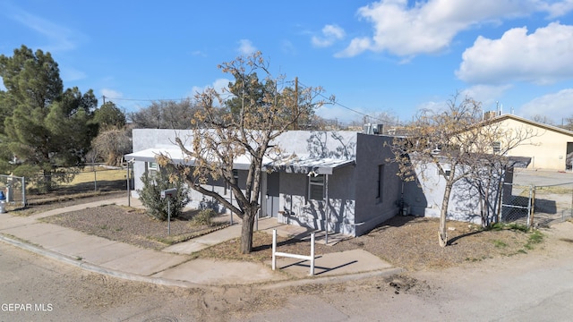 view of front of home featuring fence and stucco siding