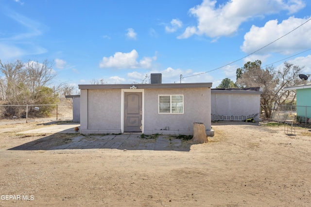 back of house with fence and stucco siding