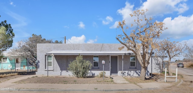 view of front of house featuring fence and stucco siding