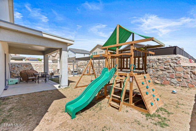 view of play area with a patio area and fence