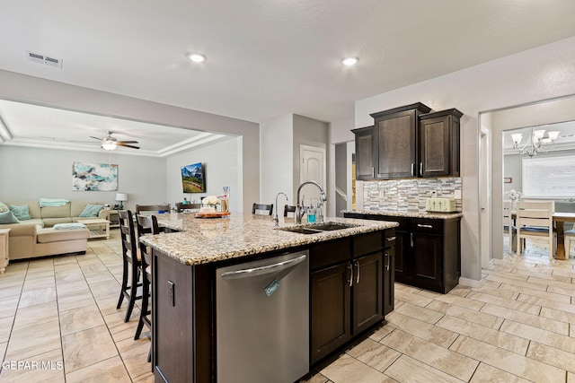 kitchen featuring stainless steel dishwasher, tasteful backsplash, a sink, ceiling fan with notable chandelier, and open floor plan