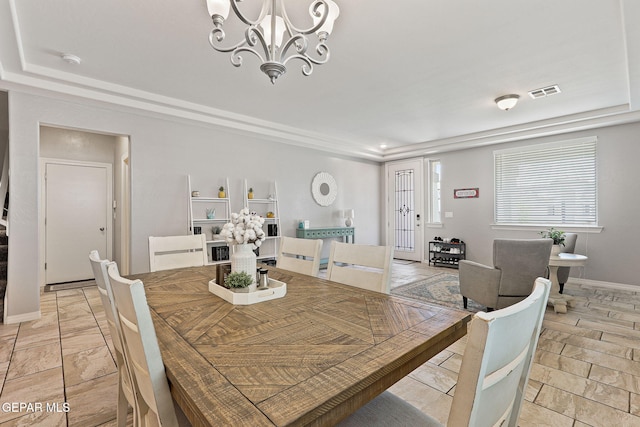 dining area with an inviting chandelier, stone finish floor, visible vents, and baseboards