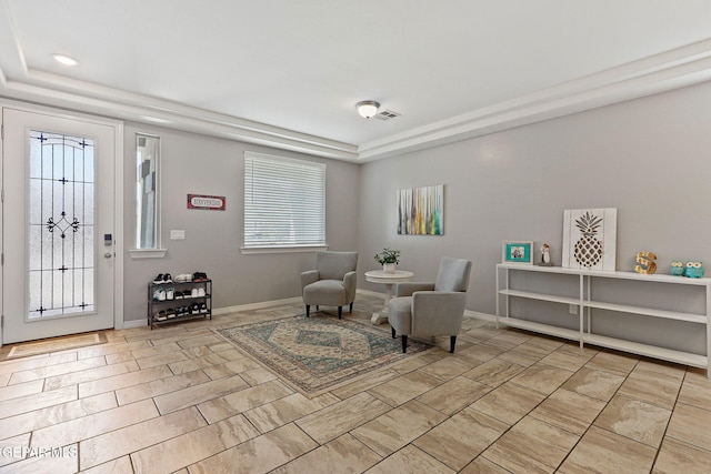 sitting room featuring a raised ceiling, visible vents, and baseboards