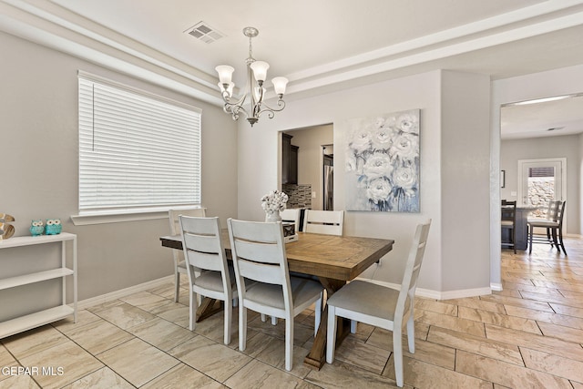 dining room with visible vents, baseboards, and a notable chandelier