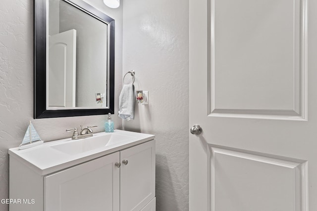 bathroom featuring a textured wall and vanity