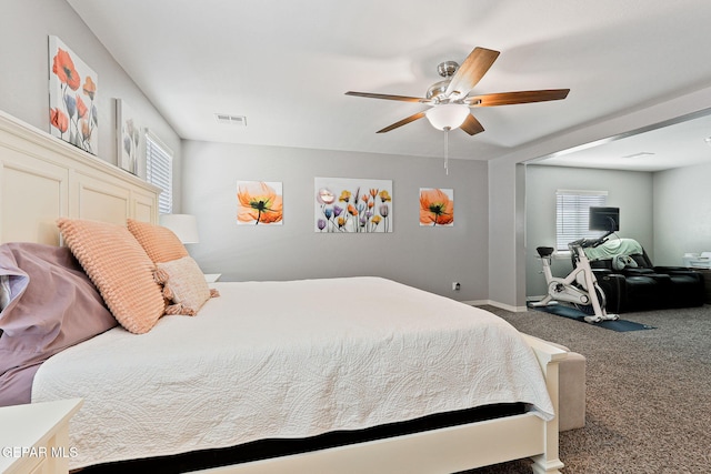 carpeted bedroom featuring baseboards, visible vents, and ceiling fan