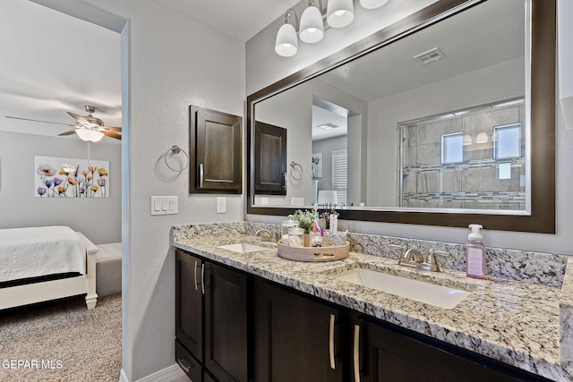 ensuite bathroom with a ceiling fan, a sink, visible vents, and double vanity