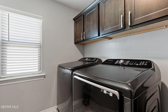 laundry room with separate washer and dryer and cabinet space