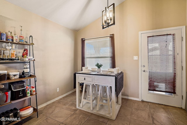 tiled dining area featuring lofted ceiling and baseboards