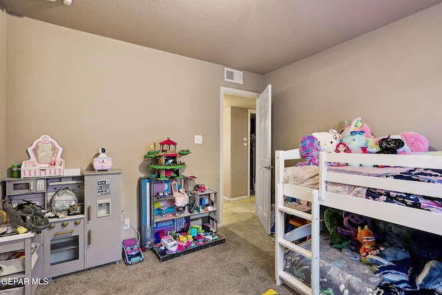 carpeted bedroom featuring visible vents and a textured ceiling