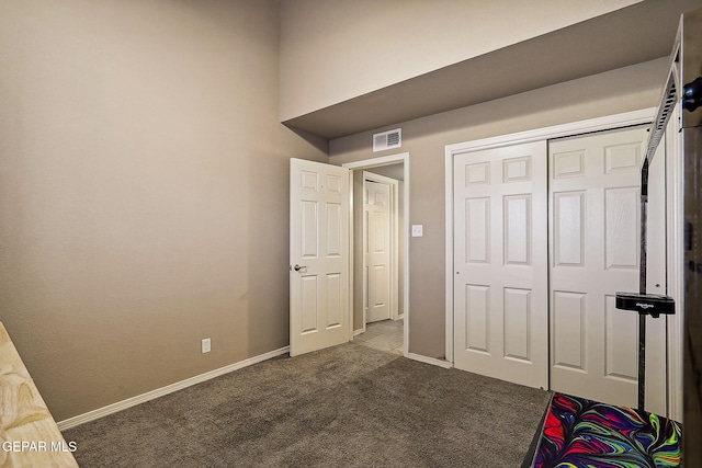 unfurnished bedroom with carpet floors, a closet, visible vents, and baseboards