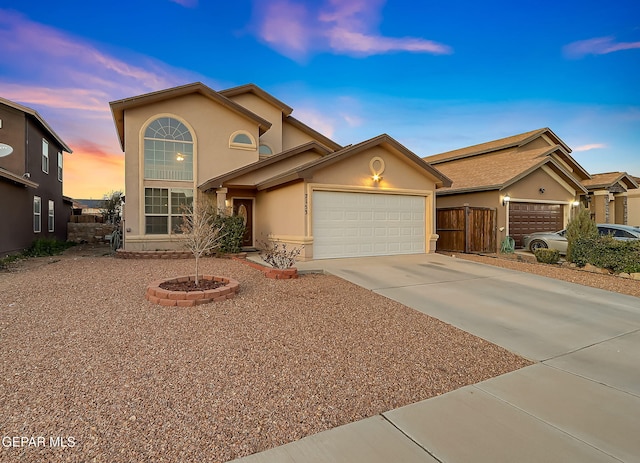 view of front of home featuring a garage, driveway, and stucco siding