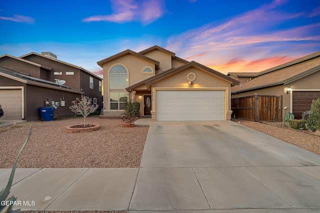 view of front of house featuring driveway, an attached garage, and stucco siding