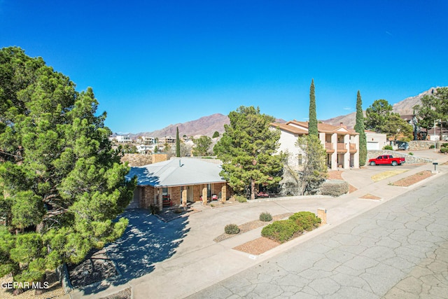 view of front of property featuring a mountain view, concrete driveway, and brick siding