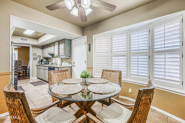 dining area featuring light tile patterned floors, visible vents, a textured wall, ceiling fan, and baseboards