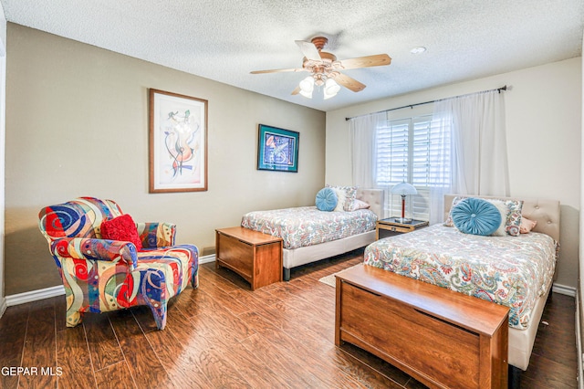 bedroom with a textured ceiling, ceiling fan, wood finished floors, and baseboards