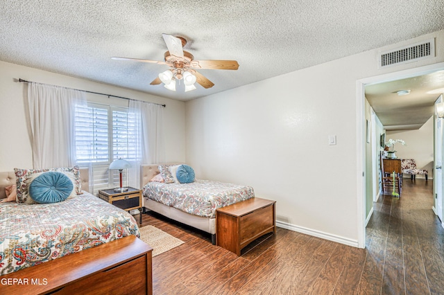 bedroom featuring baseboards, visible vents, a ceiling fan, dark wood-style floors, and a textured ceiling