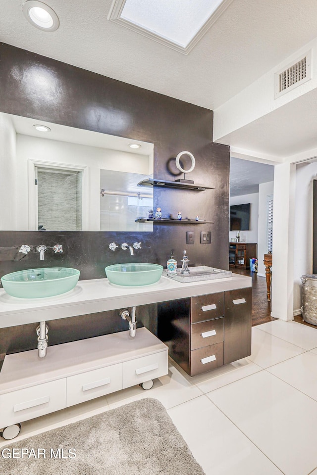 full bathroom featuring tile patterned floors, visible vents, a sink, and double vanity