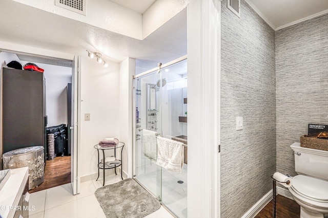 bathroom featuring visible vents, toilet, a stall shower, tile patterned flooring, and baseboards