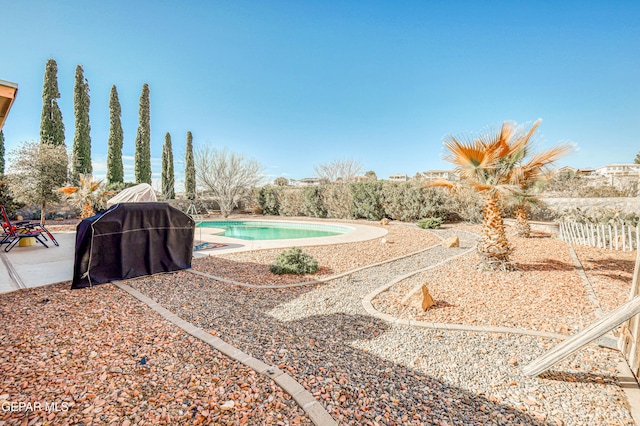 view of yard featuring an outdoor pool, a patio, and fence