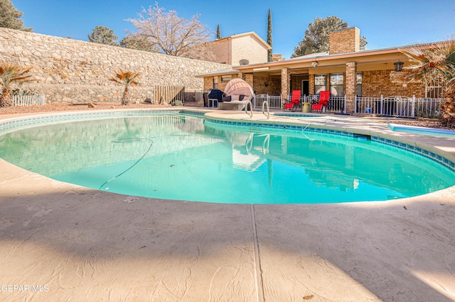 view of swimming pool featuring a patio area, fence, and a fenced in pool