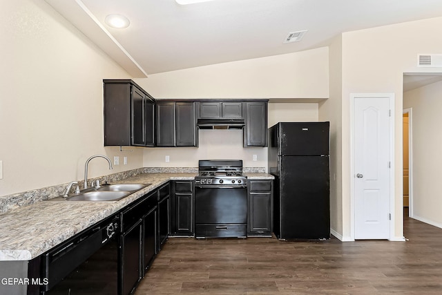 kitchen with vaulted ceiling, visible vents, a sink, and black appliances