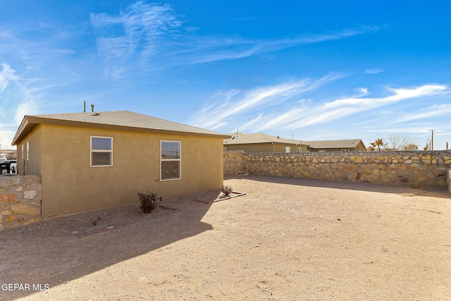 exterior space featuring fence and stucco siding