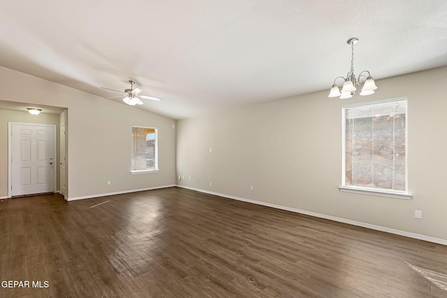 spare room featuring lofted ceiling, baseboards, dark wood-style flooring, and ceiling fan with notable chandelier