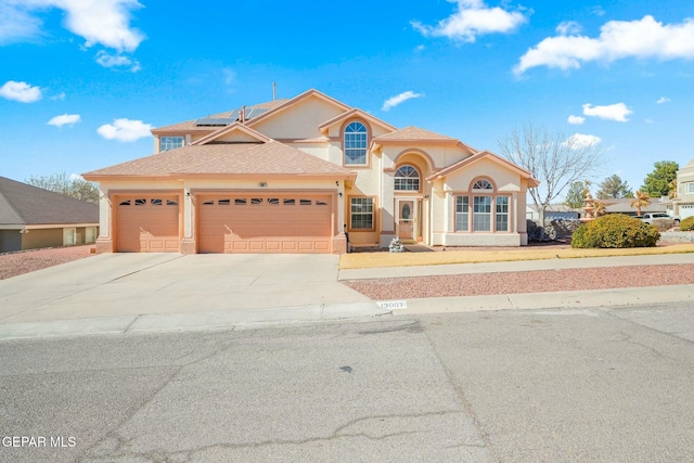 view of front of property with a garage, concrete driveway, solar panels, roof with shingles, and stucco siding